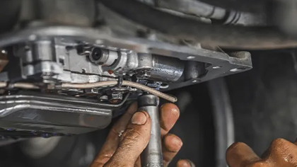 Mechanic repairing drivetrain components, focusing on differential assembly, emphasizing auto maintenance and repair services.