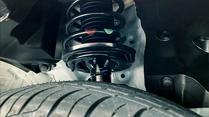 Suspension system components including coil spring and tire, highlighting vehicle maintenance and repair services.
